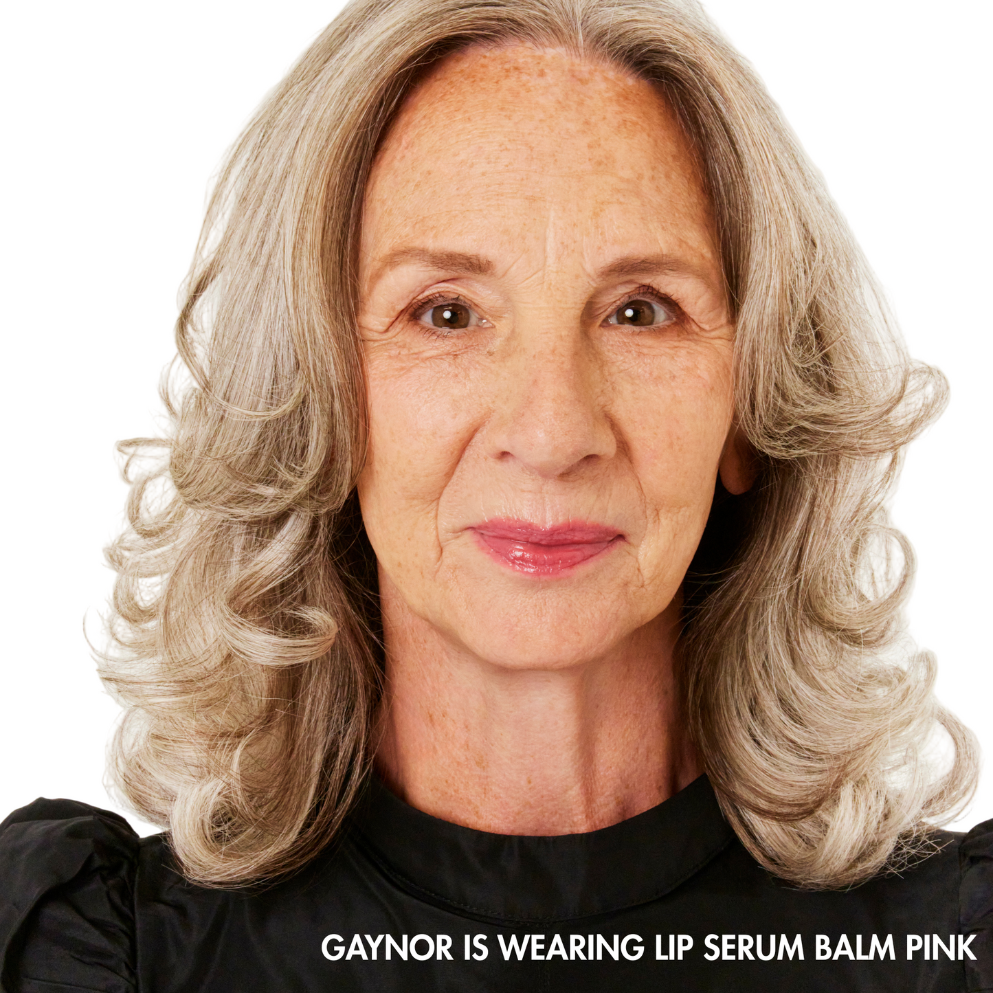 Woman with gray hair wearing a black top against a white background