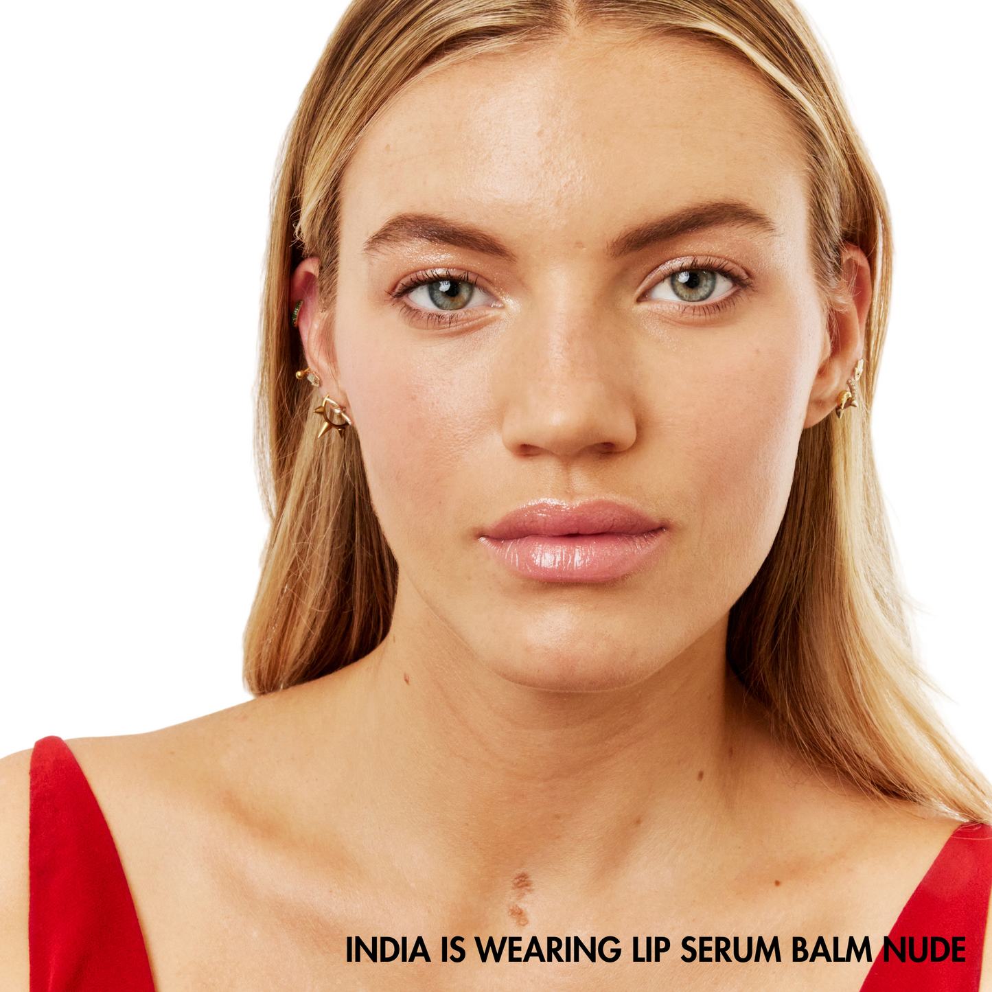 Woman wearing a red top with text indicating lip serum balm color