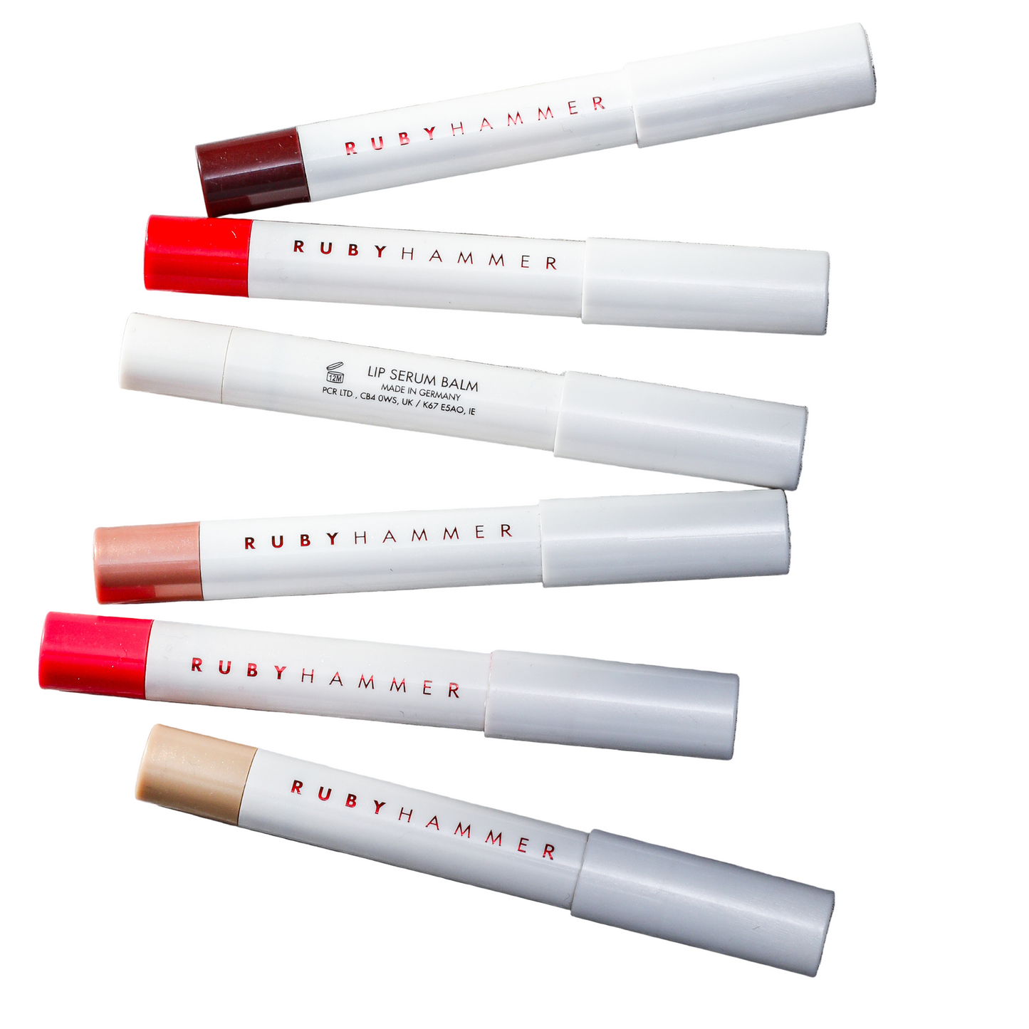 Ruby Hammer lip balm tubes on a gray surface