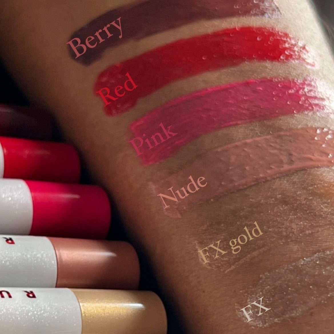 Lipstick swatches on a brown surface with labels for color and brand.