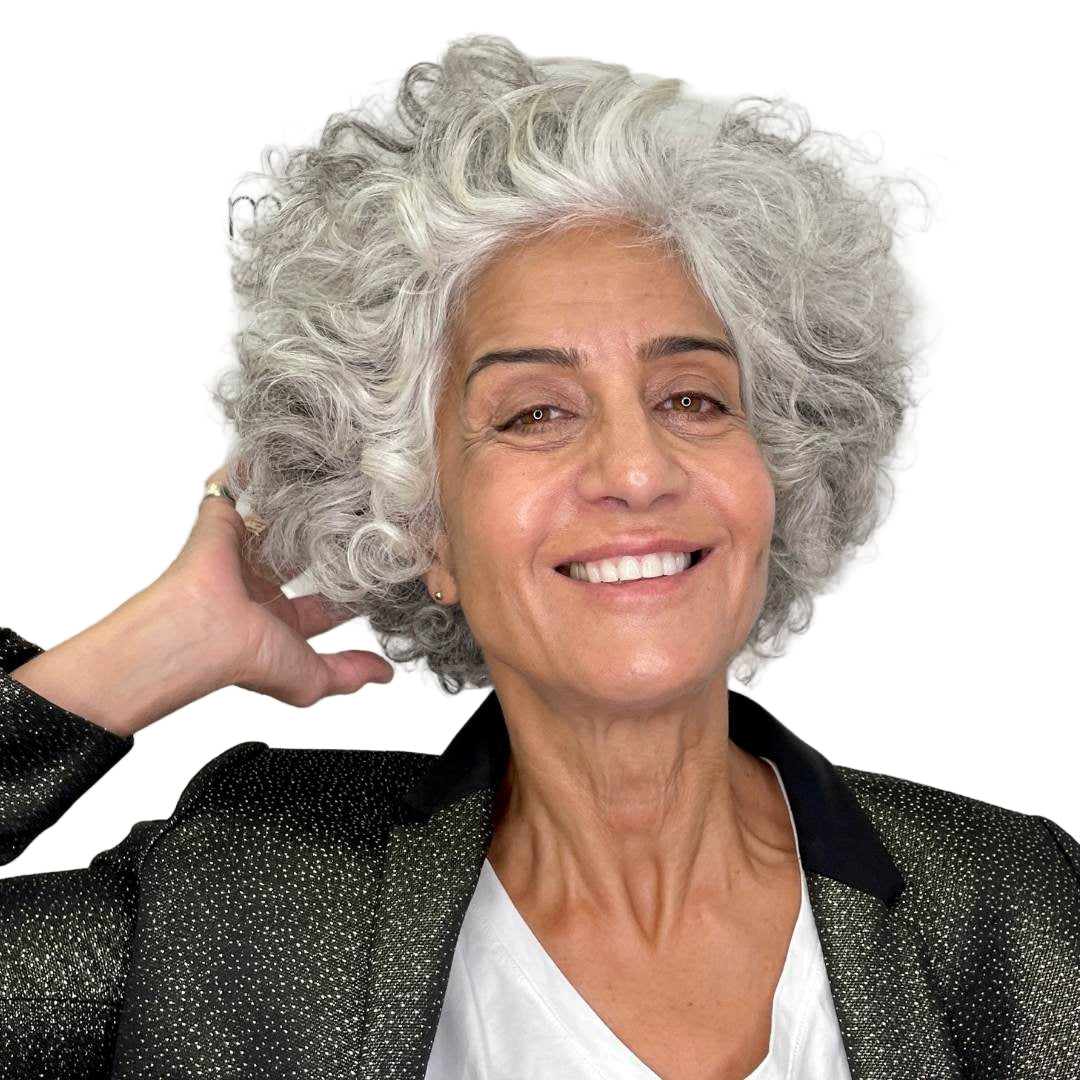 Woman with gray hair smiling against a plain background
