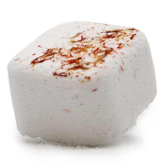 White bath bomb with brown specks on a white background