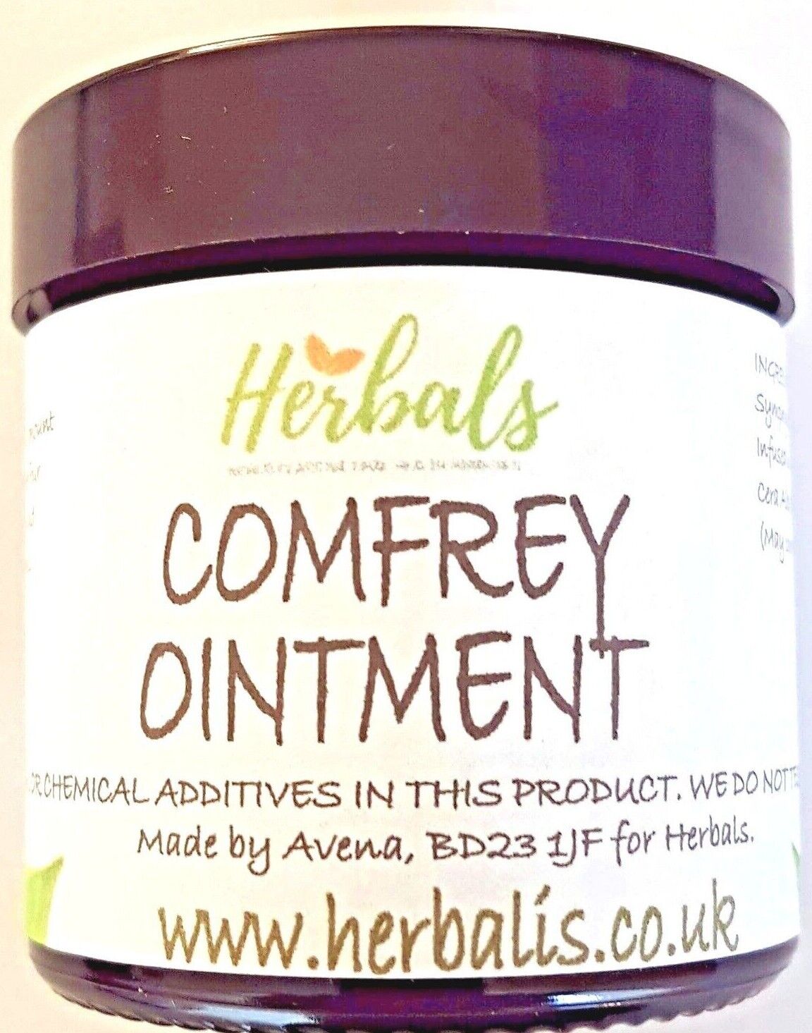 A close-up photo of a jar of "Comfrey Ointment" from the brand Herbals. The label states it is made with no chemical additives, and includes the website www.herbalis.co.uk. The jar has a dark purple lid and a white label with green and brown text.