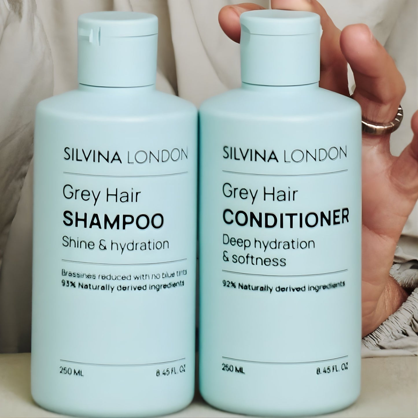 Two bottles of Silvina London Grey Hair Shampoo and Conditioner on a neutral background